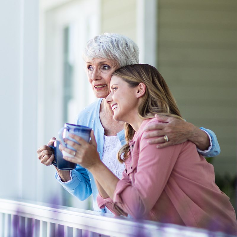 Mother and Daughter drinking coffee on a porch