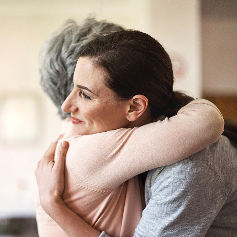 Woman hugging elderly woman