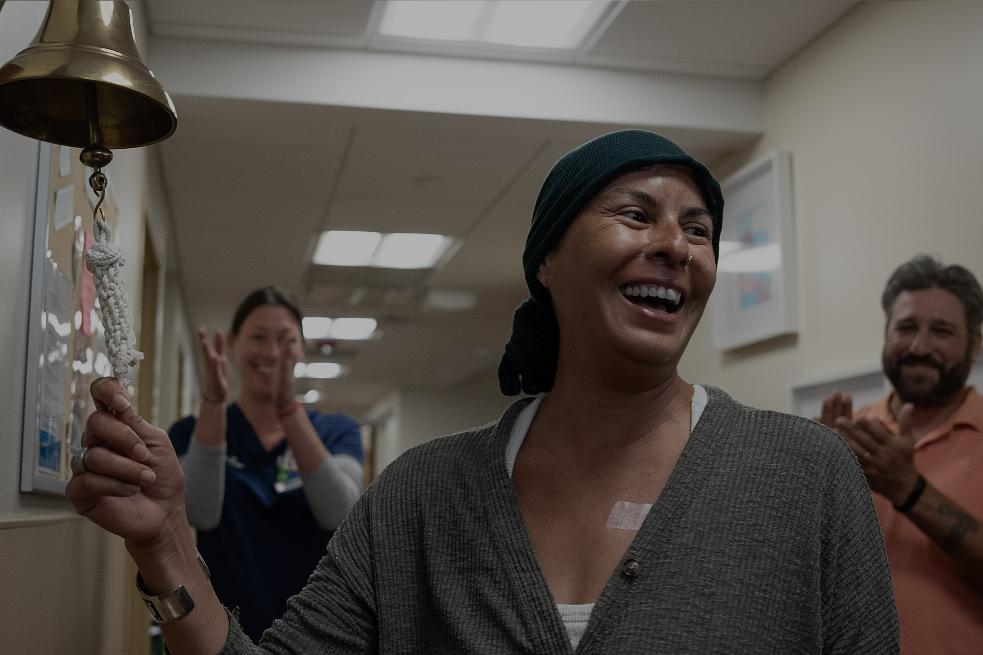 Smiling patient ringing a bell.