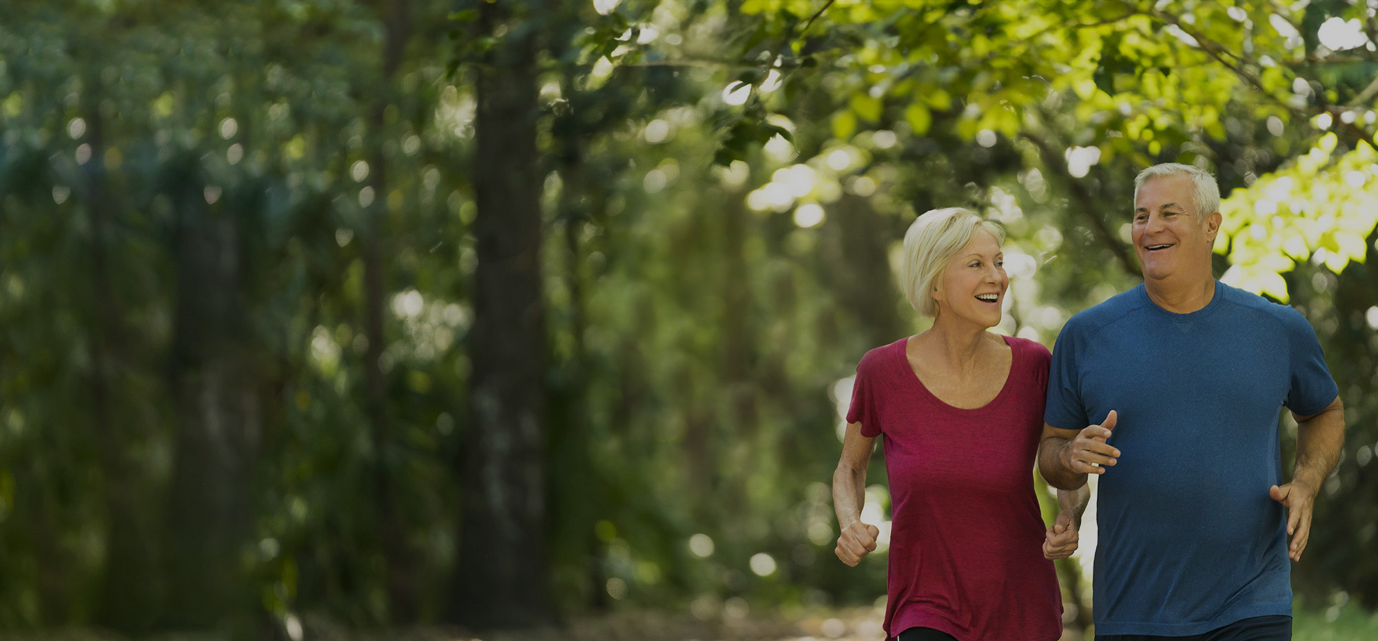 Older couple running together outdoors.