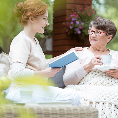 Mother and daughter outside drinking tea together